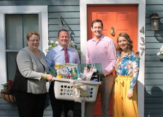 HFCU VP of Mortgage and AVP of Mortgage presents Bryan and Allysann Ingram with a gift basket for their new home