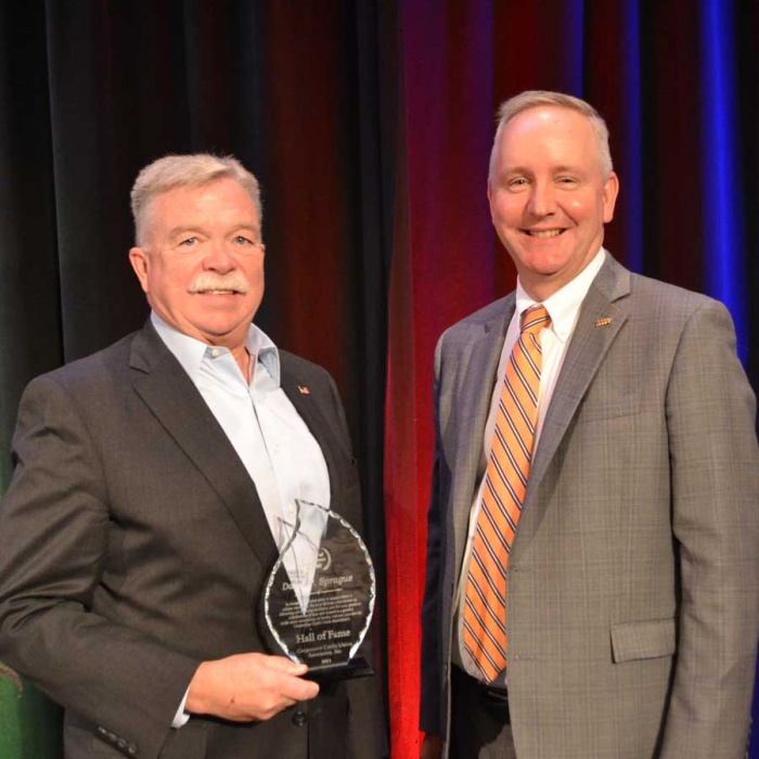 David Sprague Hanscom FCUs president and CEO holding his Hall of Fame award and standing next to Cooperative Credit Union Association President and CEO Ron McLean