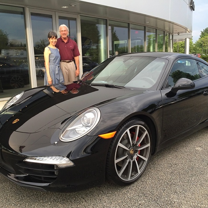 couple-standing-by-black-Porsche