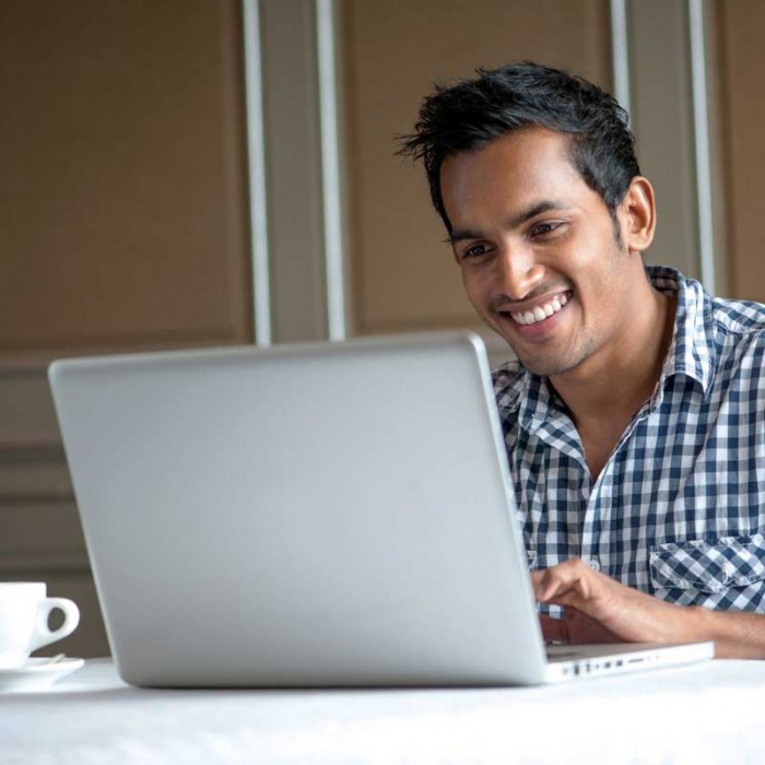smiling man working on laptop computer