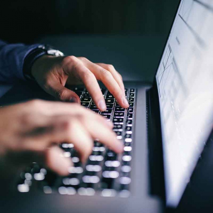 close up of hands on laptop keyboard