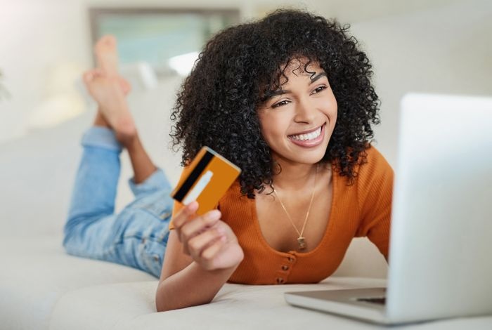 young woman shopping online with credit card and laptop