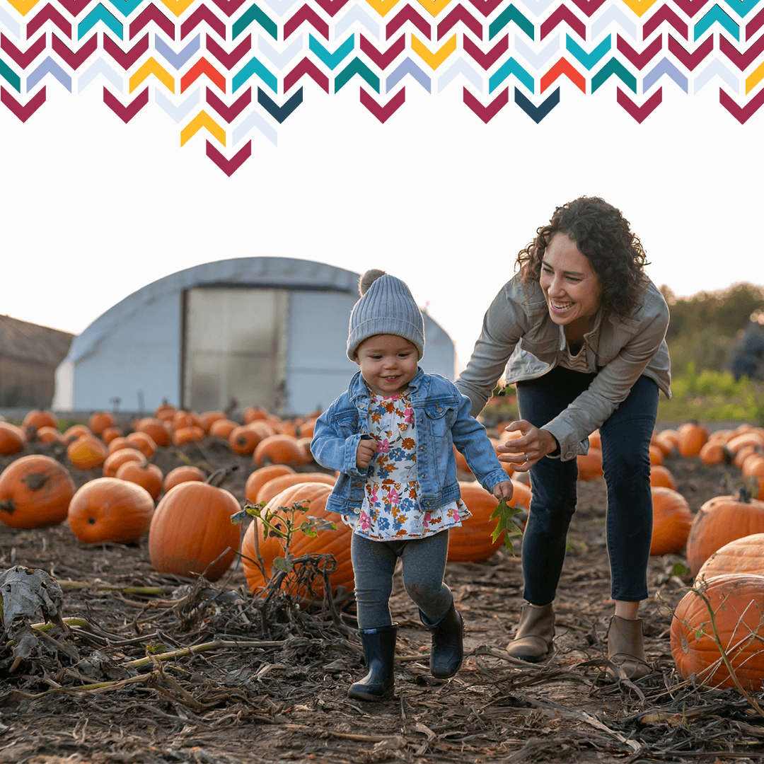 mom and daughter playing with pumpkins