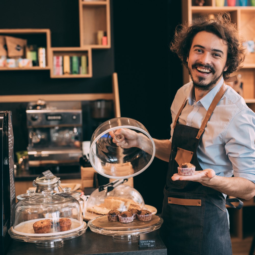 man serving pastries in cafe