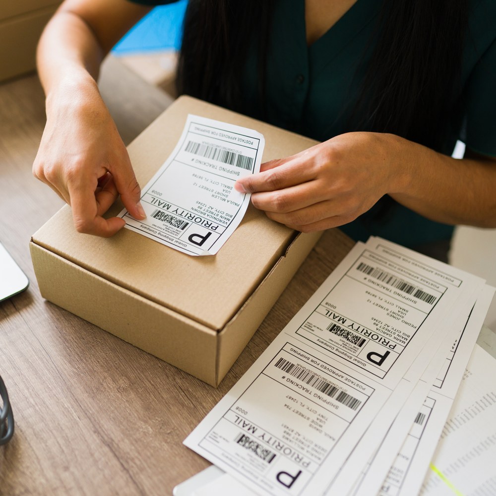woman applying mailing labels to boxes